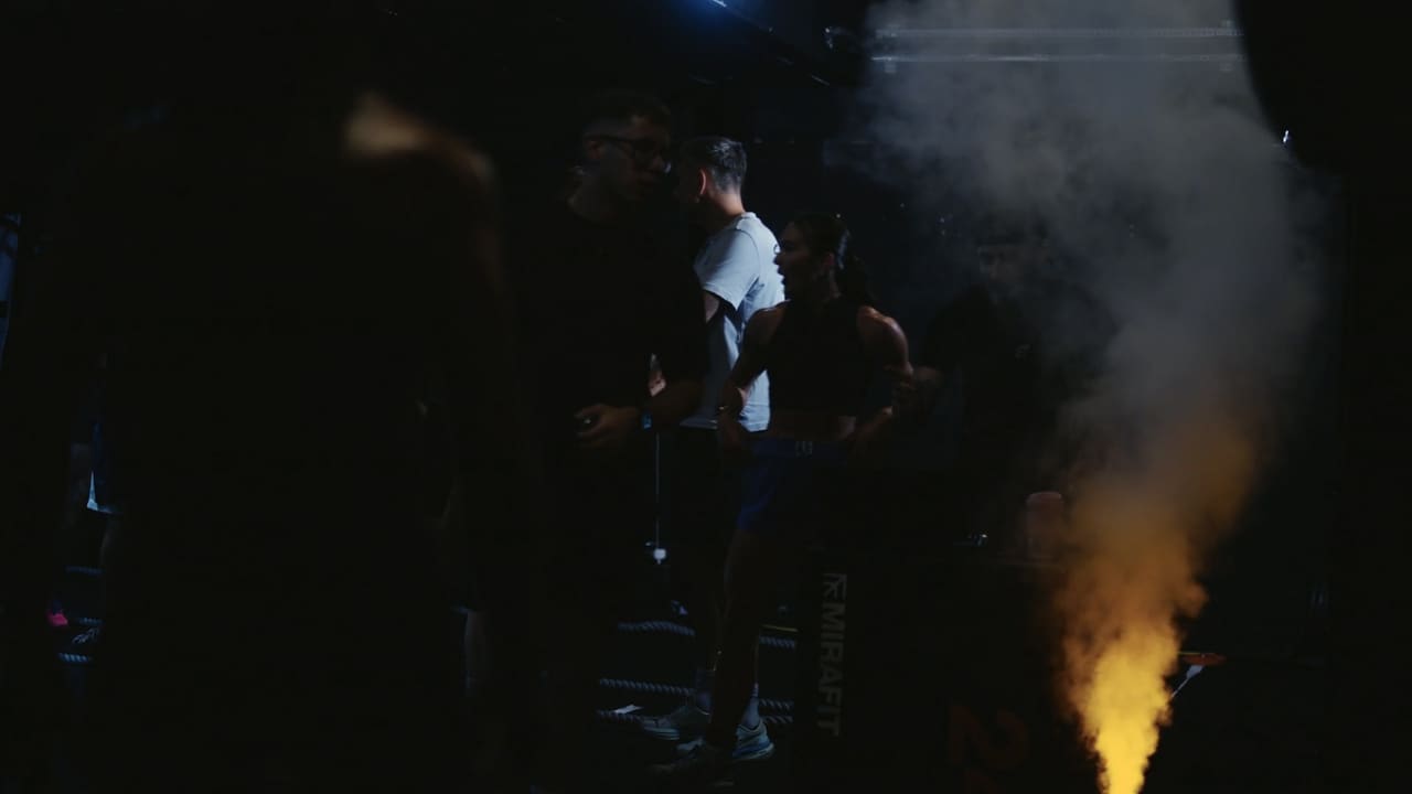 Coloured smoke flare in a dark gym during a fitness race